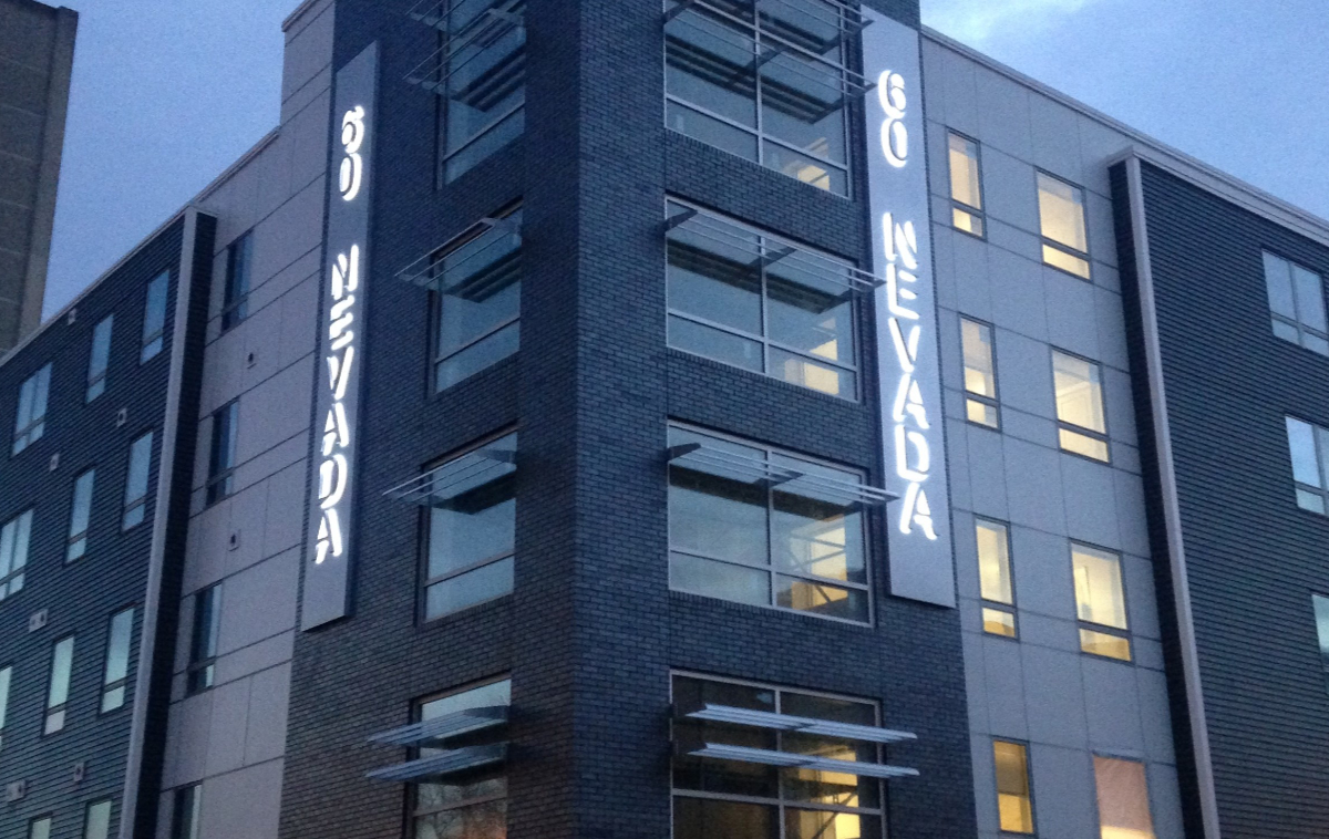 grey-condo-building-with-signage